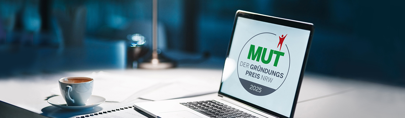 Laptop auf einem Schreibtisch, auf dem Bildschirm ist das Logo von „MUT – Der Gründungspreis NRW 2025“ zu sehen.